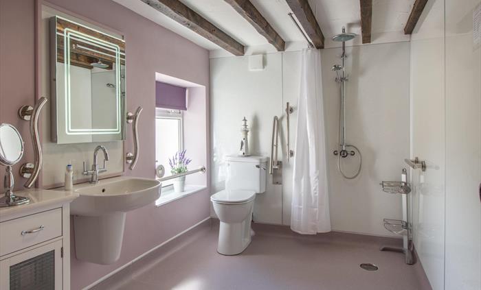 Spacious wet-room, none-slip flooring, grab tails next to comfort toilet, sink and shower. Shower chair available if needed.